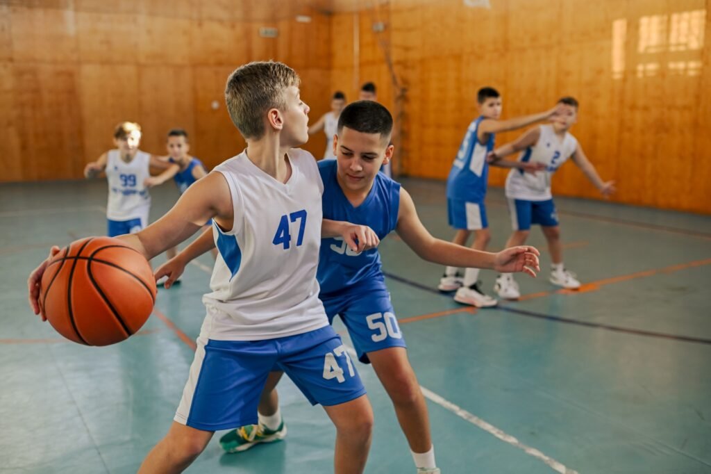 Junior basketball team is practicing game at indoor court.