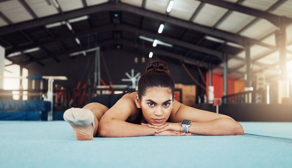 Woman stretching on floor at health gym, doing workout exercise at sports club and training for fit