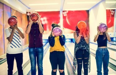 Friends bowling together indoors